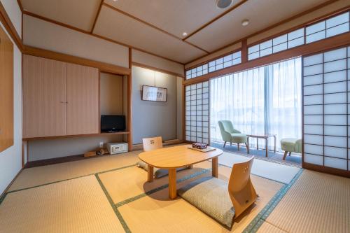 ein Zimmer mit einem Tisch und Stühlen in einem Zimmer in der Unterkunft Ryokan Ryokufuso in Kyoto