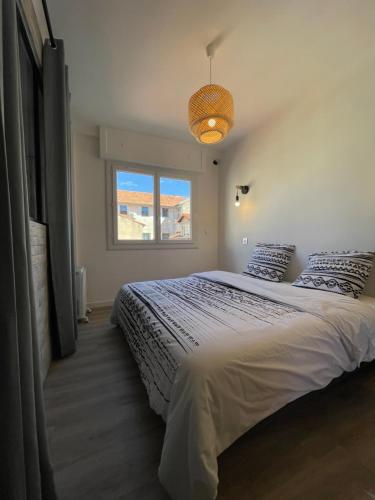 une chambre avec un grand lit et une fenêtre dans l'établissement Modern and pleasant apartment in the heart of the city, à Cannes