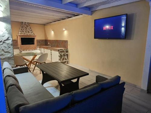 sala de estar con mesa y TV en la pared en villa bonita en Corralejo