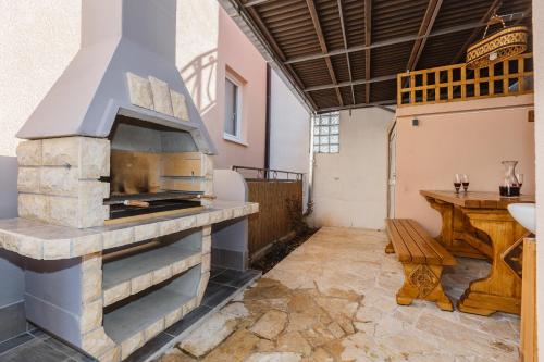 a large outdoor oven in a room with a table at Apartments Viljac in Trogir