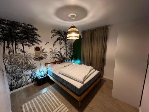 1 dormitorio con 1 cama con un mural de plantas en la pared en Maison familiale 4 chambres avec jardin et piscine en Saint-Aignan-Grand-Lieu