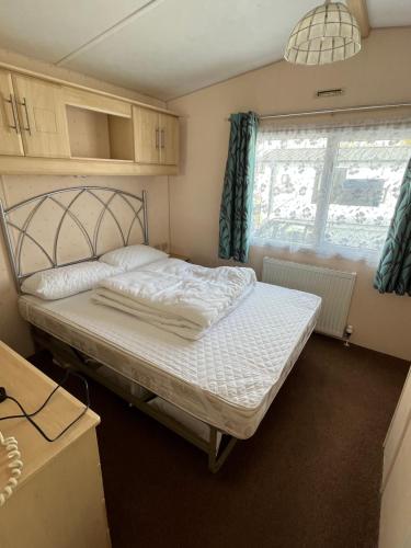 a bedroom with a bed in a room with a window at Eagle 63, Scratby - California Cliffs, Parkdean, sleeps 6, pet friendly, bed linen and towels included - close to the beach in Scratby