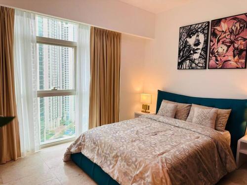 - une chambre avec un grand lit et 2 fenêtres dans l'établissement Ocean Terrace Apartment, à Abu Dhabi