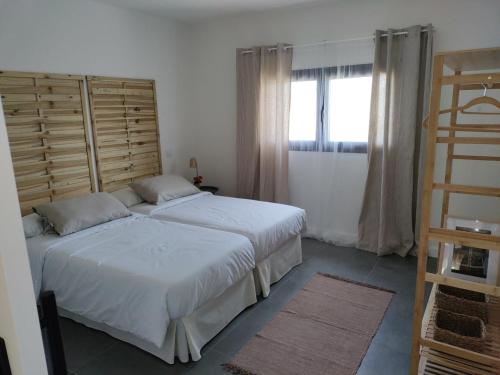 a bedroom with two beds and a window at La Cobija Apartamentos - Solo Adultos in Ciudad Real