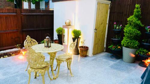 a patio with a table and chairs and potted plants at Modern cosy room with private bathroom in Harrow