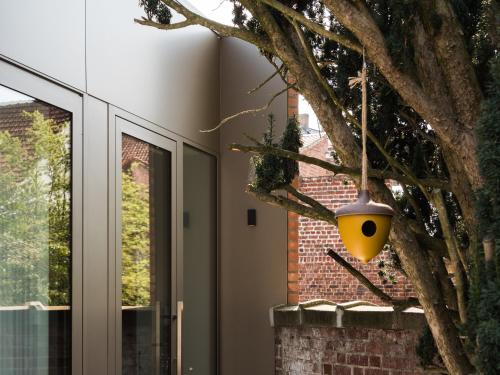 a yellow bird ornament hanging from a tree at Villa Ernest in Ypres