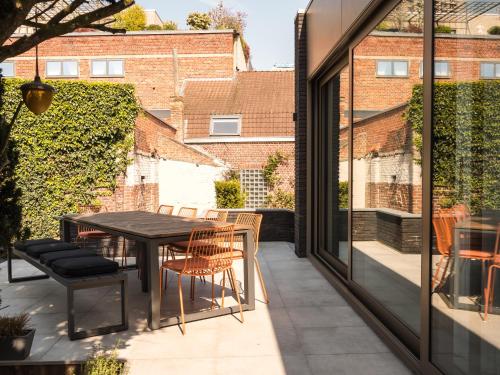 a patio with a table and chairs on a balcony at Villa Ernest in Ypres