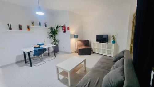 Apartamentos azayara في فرونتيرا: غرفة معيشة مع أريكة وطاولة