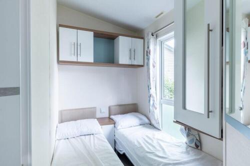 a small room with two beds and a window at Mobilhome familial de luxe 3 chambres in Onzain