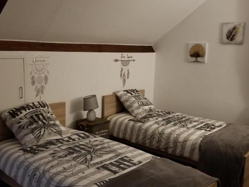ein Schlafzimmer mit 2 Betten und einem Kreuz an der Wand in der Unterkunft Le Jardin des Lumières à La Primaube in Flavin
