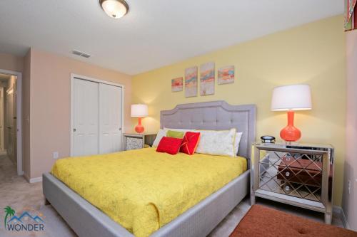 1 dormitorio con 1 cama con sábanas amarillas y almohadas rojas en Four Bedrooms Townhome 5126K, en Kissimmee