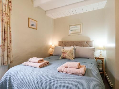 a bedroom with a bed with pink towels on it at Delft Cottage in Robin Hood's Bay