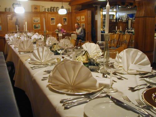 a long table with white plates and silverware on it at Kurhotel Würdinger Hof in Bad Füssing