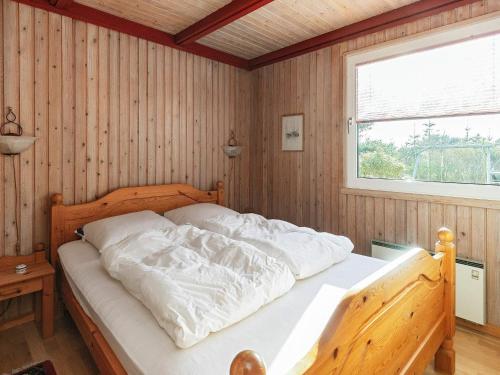 a bed in a wooden room with a window at Two-Bedroom Holiday home in Hurup Thy 2 in Sindrup