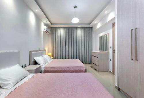pokój hotelowy z dwoma łóżkami i telewizorem w obiekcie Villa Marina w mieście Jalisos