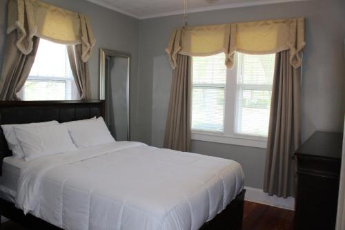 a bedroom with a white bed and two windows at The Flower Pot in Lexington