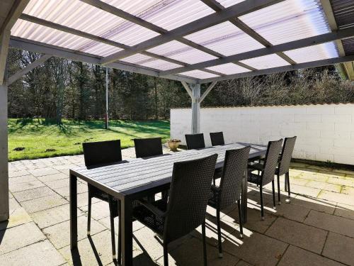 a wooden table and chairs under a pergola at 6 person holiday home in Vesløs-By Traum in Øsløs