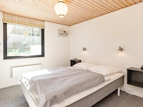 um quarto branco com uma cama e uma televisão em Holiday home Vesløs IV em Øsløs