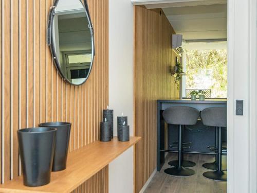 リンケビングにあるHoliday home Ringkøbing XIのバスルーム(鏡、洗面台、スツール2つ付)