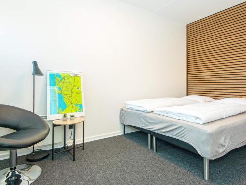 リンケビングにあるHoliday home Ringkøbing XIのベッド2台、デスク、椅子が備わる客室です。