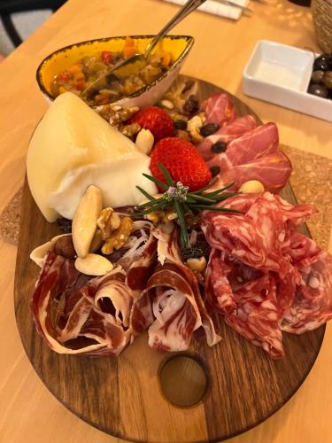 um prato de alimentos com carne e queijo sobre uma mesa em Quintinha da Oliveira em Marco de Canavezes