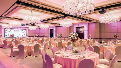 a banquet hall with tables and chairs and chandeliers at Holiday Inn Golden Mile by IHG in Hong Kong