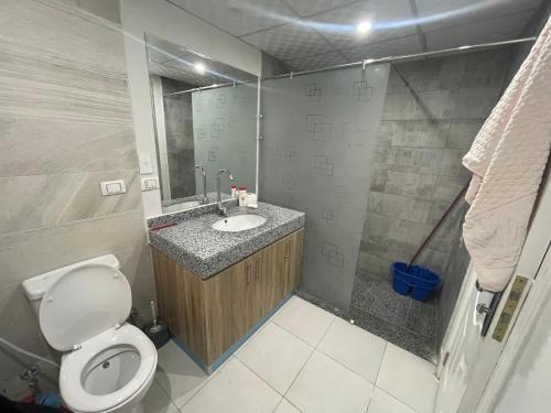 a bathroom with a toilet and a sink with a mirror at Scandic Rezort in Hurghada