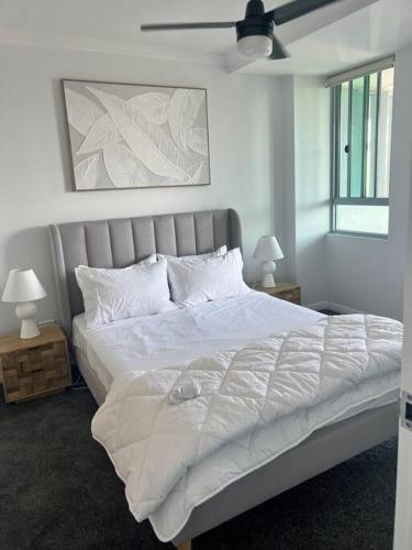 um quarto com uma grande cama branca e 2 candeeiros em Pavillions - Hosted by Burleigh Letting em Gold Coast