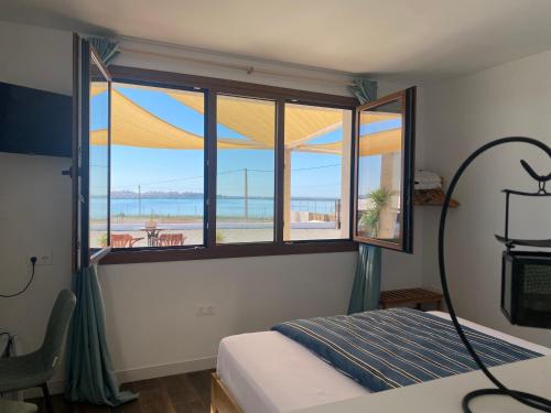 a bedroom with a window with a view of the beach at Mi Cortijo hotel de playa in Almería