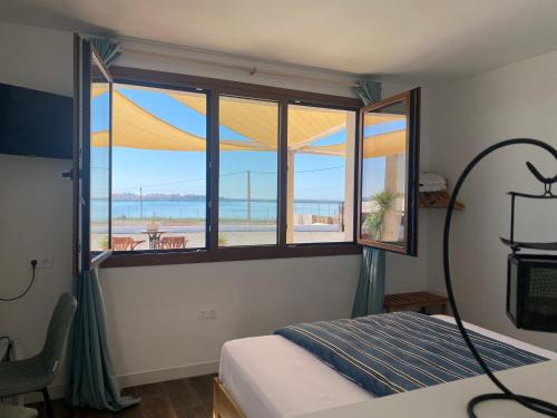 1 dormitorio con ventana y vistas a la playa en Mi Cortijo hotel de playa, en Almería