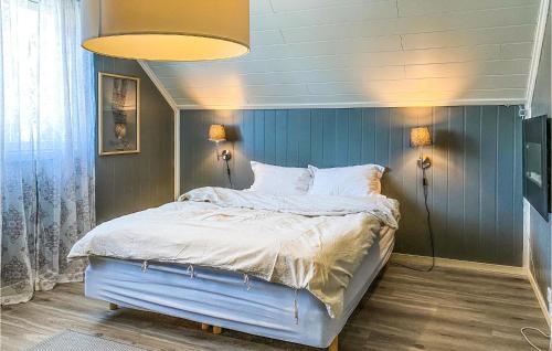 Schlafzimmer mit einem Bett mit blauer Wand in der Unterkunft Lovely Home In ydegard With Sauna 