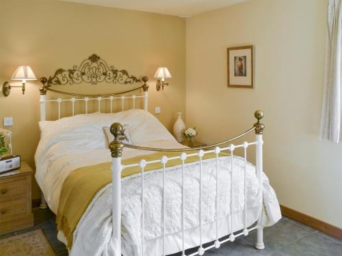 a bedroom with a white bed in a room at Riverside Cottage in Costessey