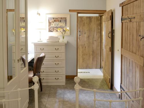 - un dressing avec une commode et un miroir dans l'établissement Riverside Cottage, à Costessey