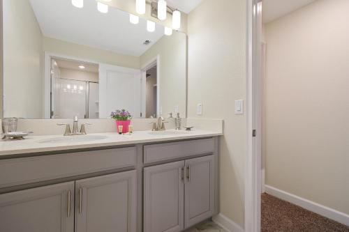 un bagno con due lavandini e un grande specchio di Four Bedrooms close to Disney w Pool 4898 a Kissimmee