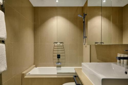 a bathroom with a bath tub and a sink at The Kinson in Melbourne