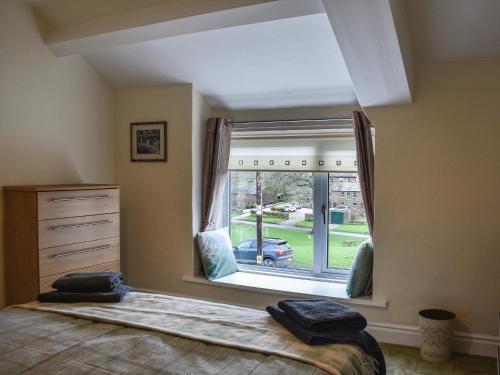 a bedroom with a large window with a car outside at Sandwath in Temple Sowerby