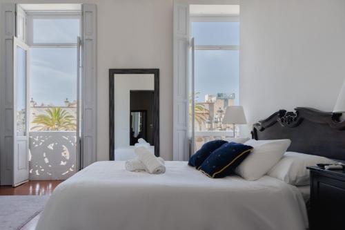 a bedroom with a large white bed with two towels on it at Santa Ana Suite & Rooms in Las Palmas de Gran Canaria