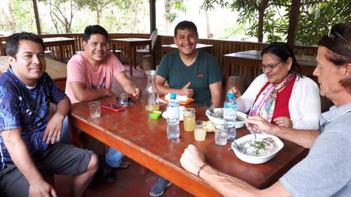 a group of people sitting around a table eating food at Summit Viewpoint House San Blas in Cusco