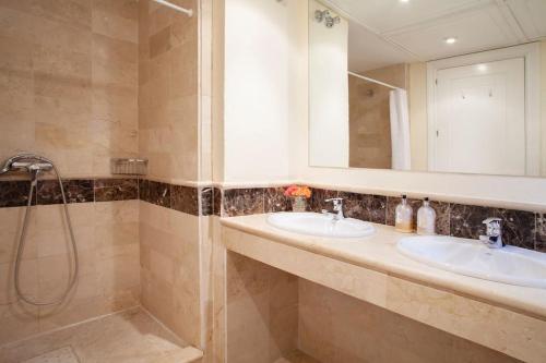 a bathroom with two sinks and a shower at Mediterranean Townhouse CalaGolf in Mijas