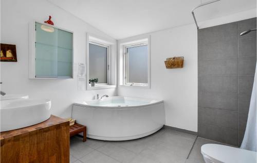 エーベルトフトにあるGorgeous Home In Ebeltoft With House Sea Viewの白いバスルーム(大型バスタブ、シャワー付)