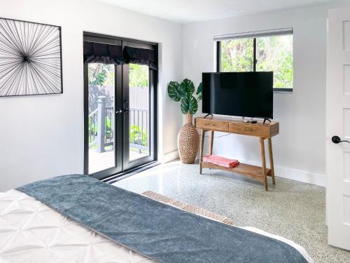 a bedroom with a television and a table with a tv at Private King Suite in Miami in Miami