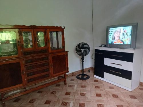 - un salon avec une télévision et une commode dans l'établissement Casa Lagoa Terraço, à Araruama