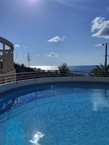 une grande piscine d'eau bleue devant un bâtiment dans l'établissement Appartement cosy, superbe vue mer, piscine., à Sète