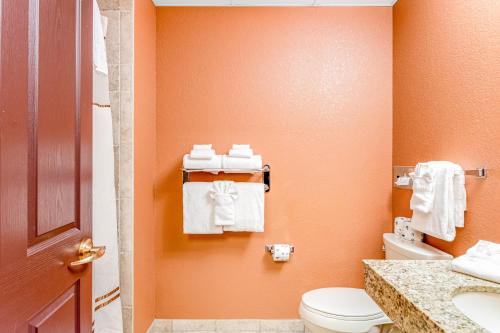 a bathroom with orange walls and a toilet and towels at Chula Vista Resort #2217 in Wisconsin Dells