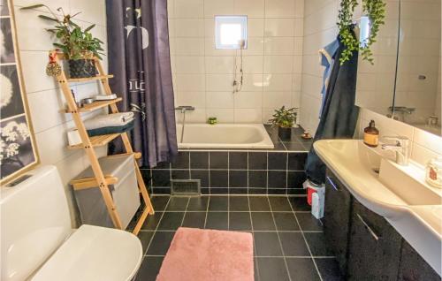 a bathroom with a tub and a toilet and a sink at Awesome Home In Varberg With Wifi And 6 Bedrooms in Varberg