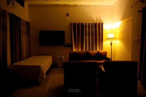 a bedroom with a bed and a tv and a couch at Tattva Luxurious Apartment in Varanasi