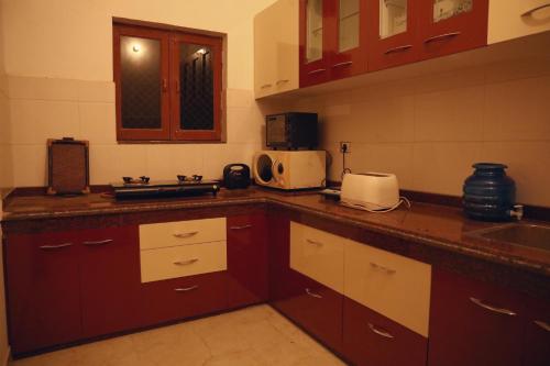 a kitchen with brown cabinets and a counter top at Tattva Luxurious Apartment in Varanasi