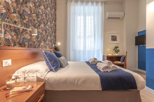 a bedroom with a bed with towels on it at Vittoria Garden Suites in Rome
