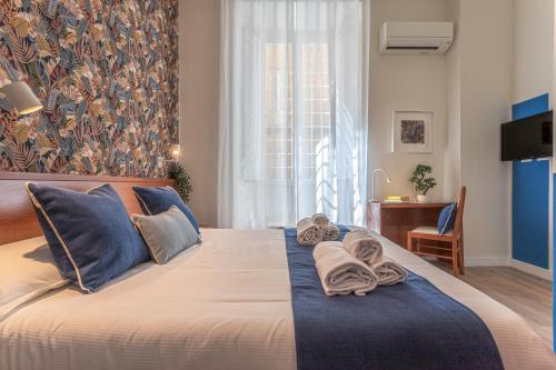 a bedroom with a large bed with towels on it at Vittoria Garden Suites in Rome