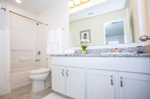 uma casa de banho com um lavatório, um WC e um espelho. em Four Bedroom Close to Disney 5149A em Kissimmee